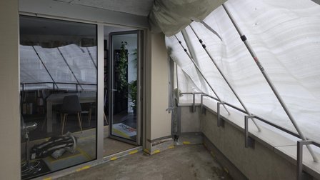Balkon mit Schutzfolie und Stangenkonstruktion vor geoeffneter Schiebetuer