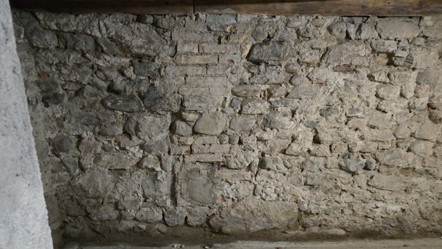 Grobe Steinwand mit unregelmäßigen Fugen, frontal aufgenommen