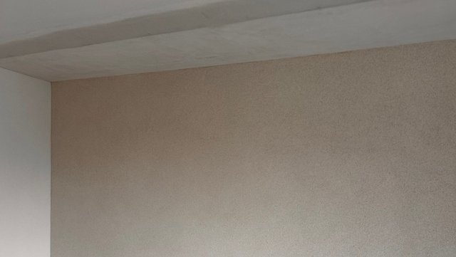Beige Wandfläche mit Deckenanschluss, Nahaufnahme der Oberfläche