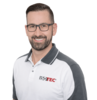 Porträt eines lächelnden ISOTEC Mitarbeiters mit Brille im Poloshirt