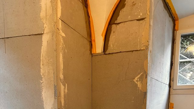 Helle Platten an Wand und Rundbogen im Innenraum, unfertige Nahaufnahme