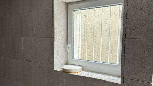 Kleines Fenster mit Gitter in heller Maueröffnung