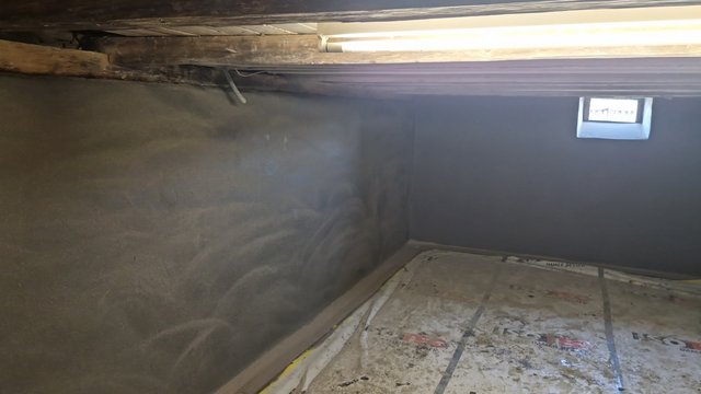 Glatter dunkler Wandbelag in niedrigem Raum mit abgedecktem Boden.