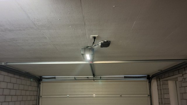 Garagendecke mit montiertem Garagentorantrieb und Führungsschiene über Tor