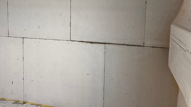 Helle Plattenwand mit Fugen und schmalem Spalt an den Kanten