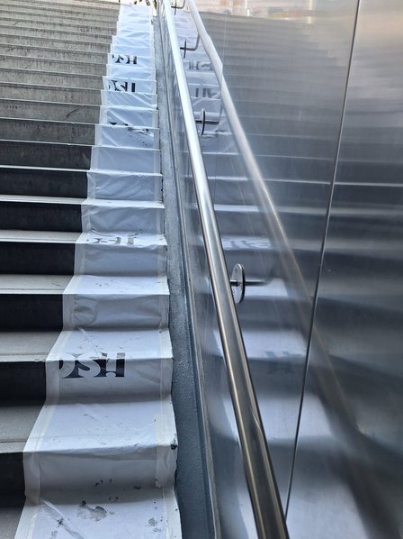 Mit Folie abgedeckte Treppe mit seitlichem Handlauf