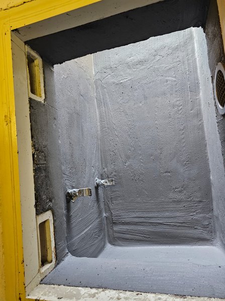 Graue Masse auf Wandnische mit zwei Metallanschlüssen, Nahaufnahme