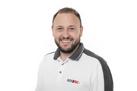 Lächelnder ISOTEC Mitarbeiter im weißen Poloshirt vor weißem Hintergrund, Porträt