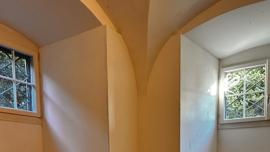 Leerer Raum mit Gewölbebogen und zwei Fenstern